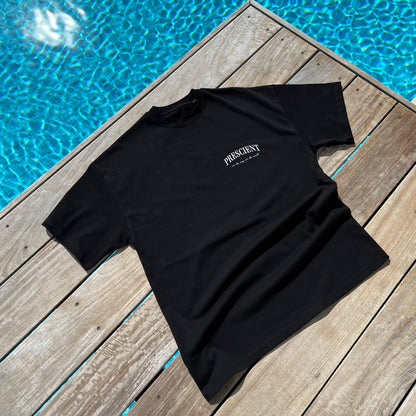 Prescient Classic Black T-Shirt laying on decking beside pool