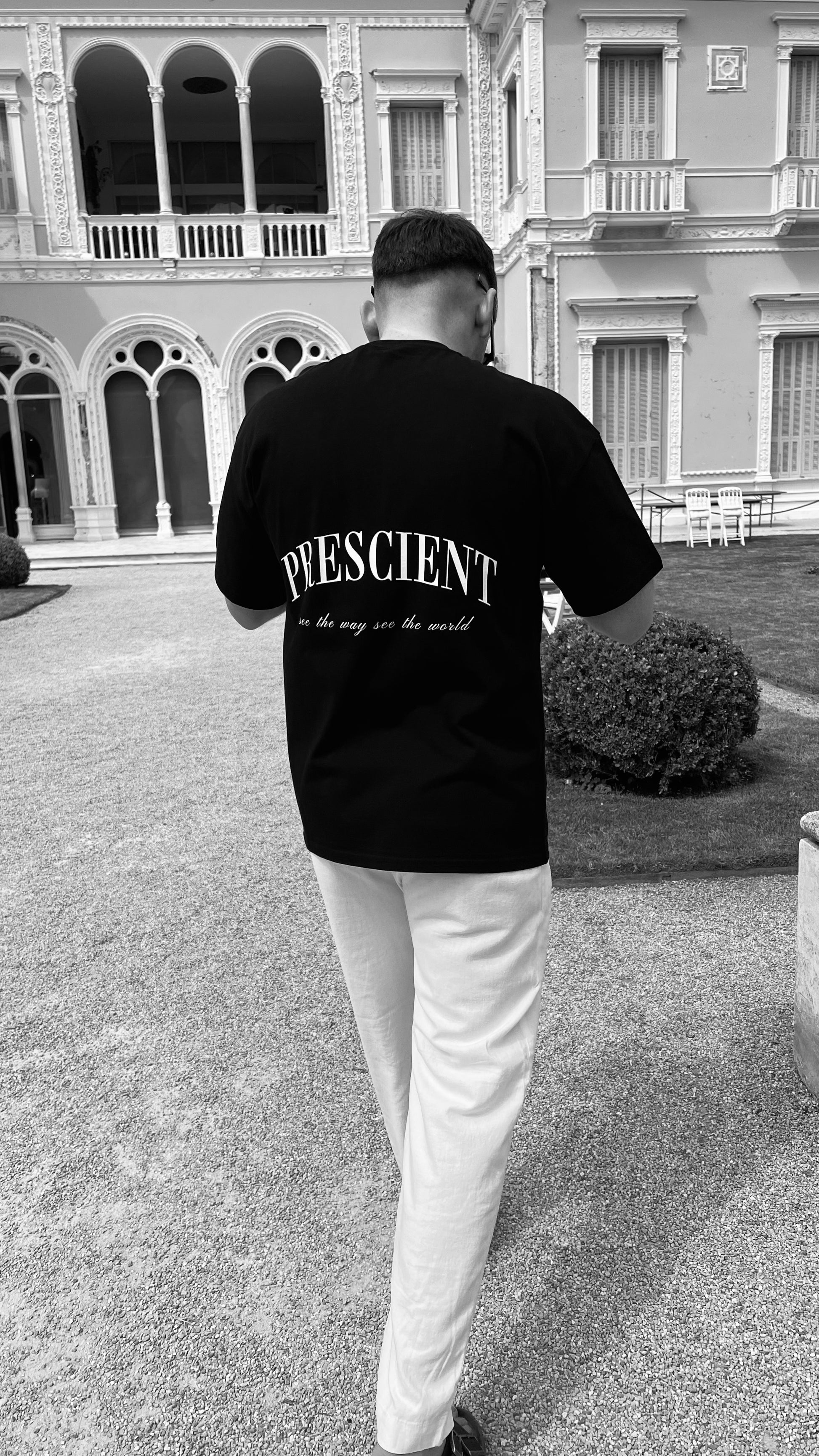 Model wearing Prescient Classic Black T-Shirt walking at Villa & Jardins Ephrusi Rothschild in Monaco